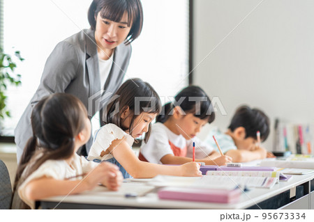 教室で勉強をする小学生と先生。 教室で勉強をする小学生と先生。 95673334