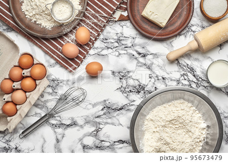 Close-up shot. Top view of a baking ingredients and kitchenware on the marble table background. Close-up shot. Top view of a baking ingredients and kitchenware on the marble table background. 95673479