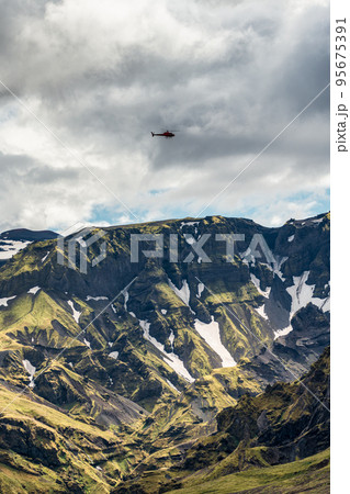 Green mountain canyon with snow covered and helicopter flying in Icelandic Highlands 95675391