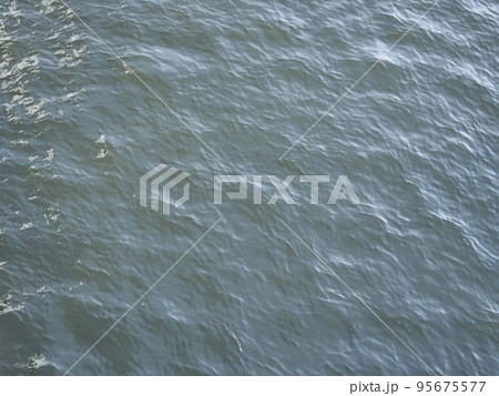 川の水面。風にゆらぐ波。 95675577