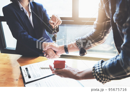 Focus on the congratulatory handshake. The real estate agent agrees to buy the home and hand the keys to the customer at the agent's office. conceptual agreement Focus on the congratulatory handshake. The real estate agent agrees to buy the home and hand the keys to the customer at the agent's office. conceptual agreement 95675716