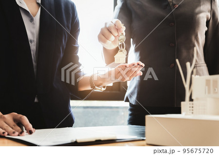 Real estate agents agree to buy a home and give keys to clients at their agency's offices. Concept agreement 95675720