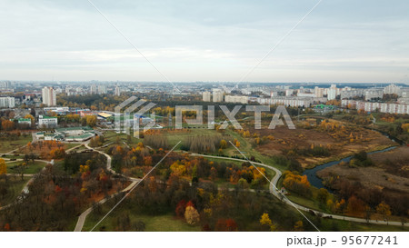 Autumn city park. Trees with colorful leaves. A cycle path winds between the trees. Autumn landscape. Aerial photography. Autumn city park. Trees with colorful leaves. A cycle path winds between the trees. Autumn landscape. Aerial photography. 95677241