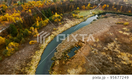 Autumn city park. A meandering river flows between the trees. Trees with colorful leaves. Autumn landscape. Aerial photography. Autumn city park. A meandering river flows between the trees. Trees with colorful leaves. Autumn landscape. Aerial photography. 95677249