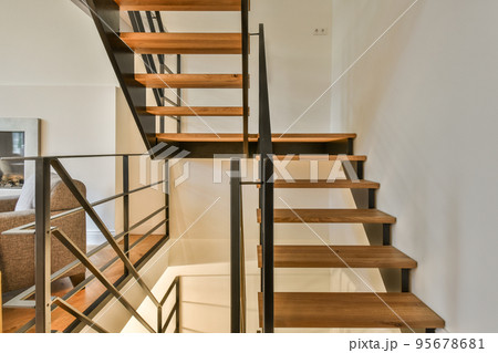 White spiral stairway connecting levels of contemporary house with wooden floor and white walls White spiral stairway connecting levels of contemporary house with wooden floor and white walls 95678681