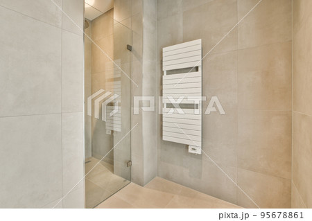 Glass partition between shower tap and wall hung toilet in modern restroom at home 95678861