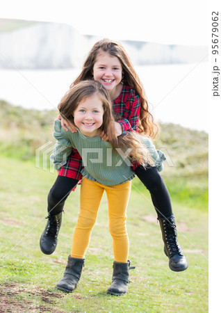 Two little girls sisters playing outdoor near Cuckmere beach located between Eastbourne and Seaford, East Sussex, British south coast, selective focus Two little girls sisters playing outdoor near Cuckmere beach located between Eastbourne and Seaford, East Sussex, British south coast, selective focus 95679062