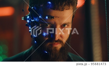 Young bearded guy in black leather jacket looks fiercely at the camera Cyberpunk Young bearded guy in black leather jacket looks fiercely at the camera Cyberpunk 95681473