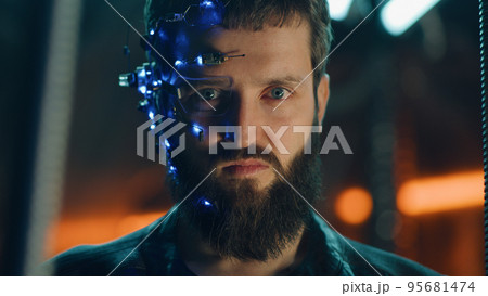 Young bearded guy in black leather jacket looks fiercely at the camera Cyberpunk Young bearded guy in black leather jacket looks fiercely at the camera Cyberpunk 95681474