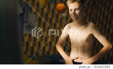 Young boy checks his abs after workout member of school sport team muscular body Young boy checks his abs after workout member of school sport team muscular body 95681904