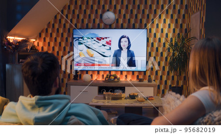 Couple watching medicine news on TV Couple watching medicine news on TV 95682019