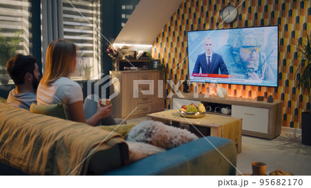 Couple watching TV news about war in Ukraine 95682170