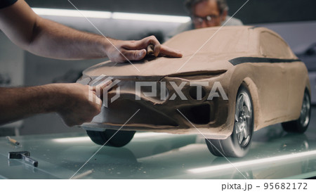 Male designers creating plasticine car model 95682172