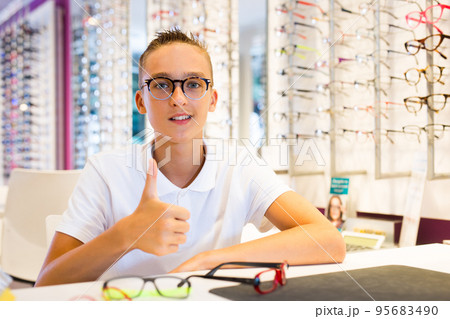Male client trying on new spectacles in medical shop Male client trying on new spectacles in medical shop 95683490