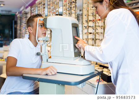 Female optometrist testing eyesight of boy 95683573