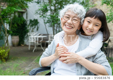車椅子のシニア女性と孫の女の子 95683876