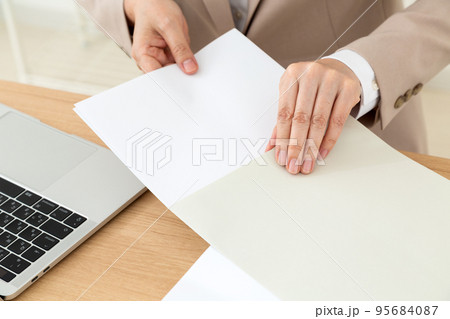 デスクワークで書類を用意するミドル女性のビジネスウーマン 95684087