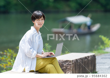 旅先でワーケーションで仕事をする女性 95684302