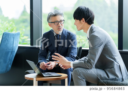 事務所で打ち合わせをするビジネスマン 95684863