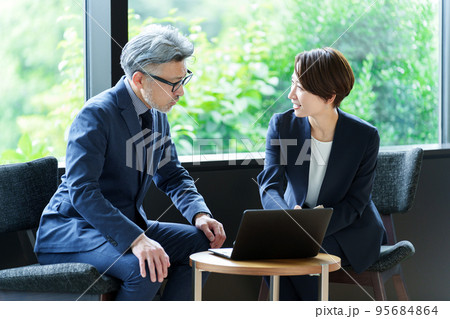 事務所で打ち合わせをするビジネスパーソン 95684864
