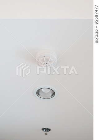 Smoke sensor detector mounted on roof in home or apartment. Safety and conflagration security concept 95687477