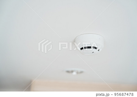 Smoke sensor detector mounted on roof in home or apartment. Safety and conflagration security concept 95687478