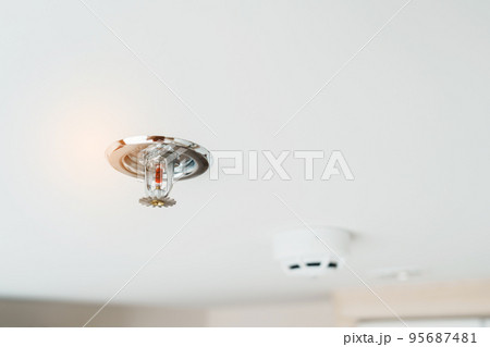 Fire Sprinkler and Smoke sensor detector mounted on roof in home or apartment. Safety and conflagration security concept Fire Sprinkler and Smoke sensor detector mounted on roof in home or apartment. Safety and conflagration security concept 95687481