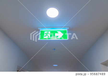 Fire Emergency exit sign on the wall background inside building. Safety concept 95687489