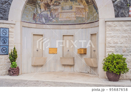 Monastery of Ostrog, Serbian Orthodox Church situated against a vertical background, high up in the large rock of Ostroska Greda, Montenegro. Dedicated to Saint Basil of Ostrog 95687658