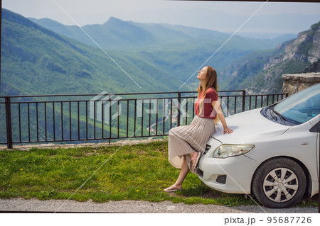 Woman tourist on background of Blue river running through green valley toward distant mountains. Beautiful mountains of Montenegro and the river Cievna Woman tourist on background of Blue river running through green valley toward distant mountains. Beautiful mountains of Montenegro and the river Cievna 95687726