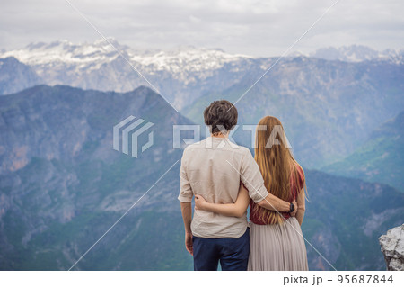 Man and woman happy couple tourists on background of Breathtaking panoramic view of the Grlo Sokolovo gorge in Montenegro. In the foreground is a mountain, the flat side of which forms a cliff, and 95687844