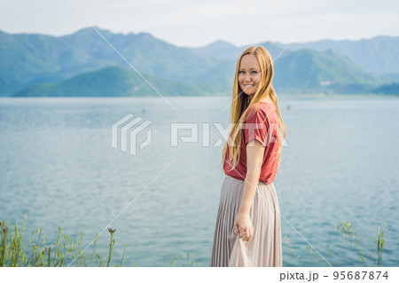 Woman tourist on background of National Park Skadar Lake. Montenegro. Skadar lake. Dawn. View from above. The largest lake in the Balkans. Mountains of the Dinaric Highlands. Swampy shores and 95687874
