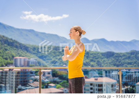 Beautiful woman doing yoga outdoors on a rooftop terrace 95687877