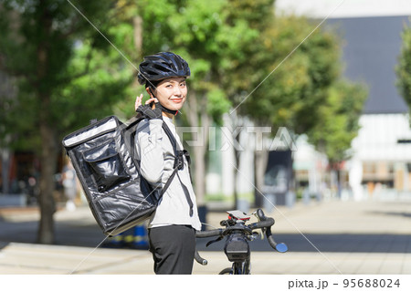 振り返ってOKサインしているフードデリバリー 配達員の女性 振り返ってOKサインしているフードデリバリー 配達員の女性 95688024