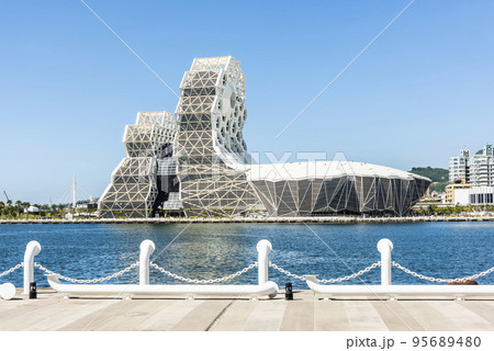 Building view of Kaohsiung Music Center in Port of Kaohsiung, Taiwan. The white hexagonal building structure on the shore of love pier. Building view of Kaohsiung Music Center in Port of Kaohsiung, Taiwan. The white hexagonal building structure on the shore of love pier. 95689480