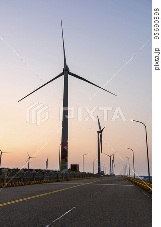 Sunset view of Gaomei Windmill Avenue in Taichung, Taiwan. It's energy systems and renewable energy. The wind power plant, energy systems, and renewable energy are on the west coast of Taiwan. 95690398