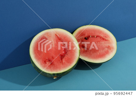 Fresh watermelon halves on two tone background Fresh watermelon halves on two tone background 95692447