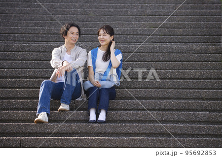 階段に座って会話する若いカップル 階段に座って会話する若いカップル 95692853