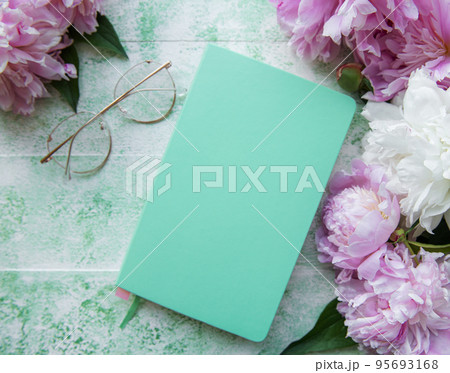 Flat lay paper notebook, eyeglasses, peony flowers 95693168