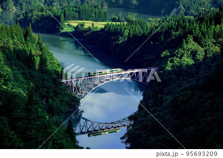 只見線　初秋の第一只見川橋梁を渡る列車キハE120形(福島県三島町、9月) 95693209