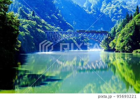 只見線　初秋の第一只見川橋梁を渡る列車キハE120形(福島県三島町、9月) 95693221