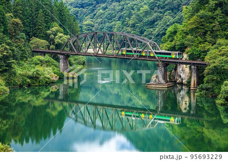 只見線　初秋の第四只見川橋梁を渡る列車キハE120形(福島県金山町、9月) 95693229