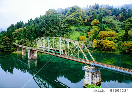 只見線　初秋の第五只見川橋梁を渡る列車キハE120形(福島県金山町、10月) 95693284