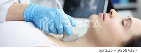 Ultrasound scanning diagnostic of woman thyroid gland in clinic, doctor runs ultrasound sensor 95694337