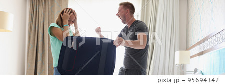 Woman in stress, husband scream and pack stuff in suitcase for work trip, couple fight 95694342