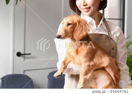 犬（ペット）を抱っこするトリマーの女性 95694761