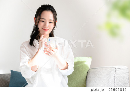 スマホをもって考えるかわいい女性　 95695013