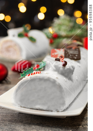 White chocolate yule log cake with christmas lights 95698388
