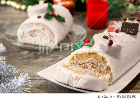 White chocolate yule log cake with christmas lights 95698390