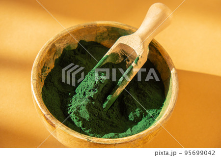 Blue-green algae Chlorella and spirulina powder in bamboo eco bowl. Super powder in spoon. Detox superfood. Natural supplement of algae Blue-green algae Chlorella and spirulina powder in bamboo eco bowl. Super powder in spoon. Detox superfood. Natural supplement of algae 95699042